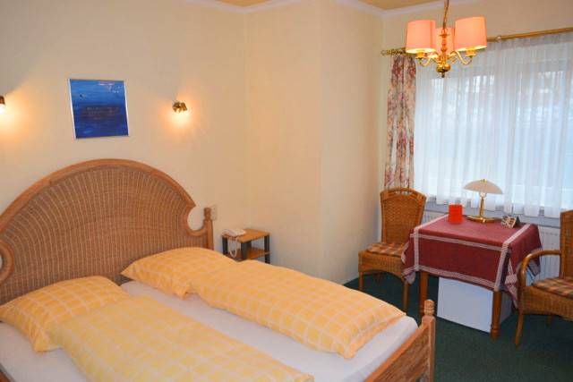 Innenansicht Doppelzimmer mit Doppelbett und Tischecke