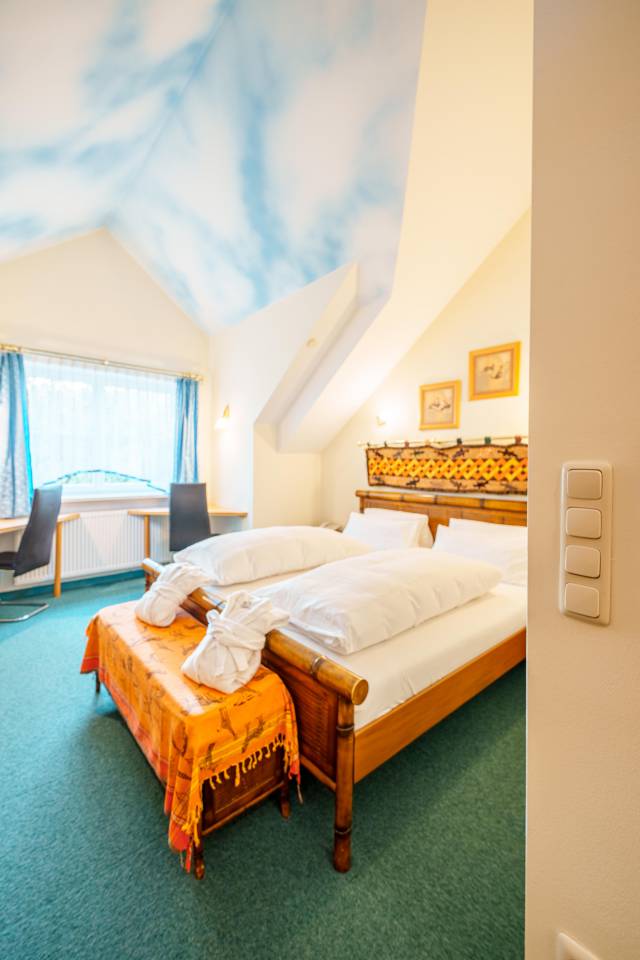 Innenansicht Doppelzimmer mit Doppelbett und Wolkendecke